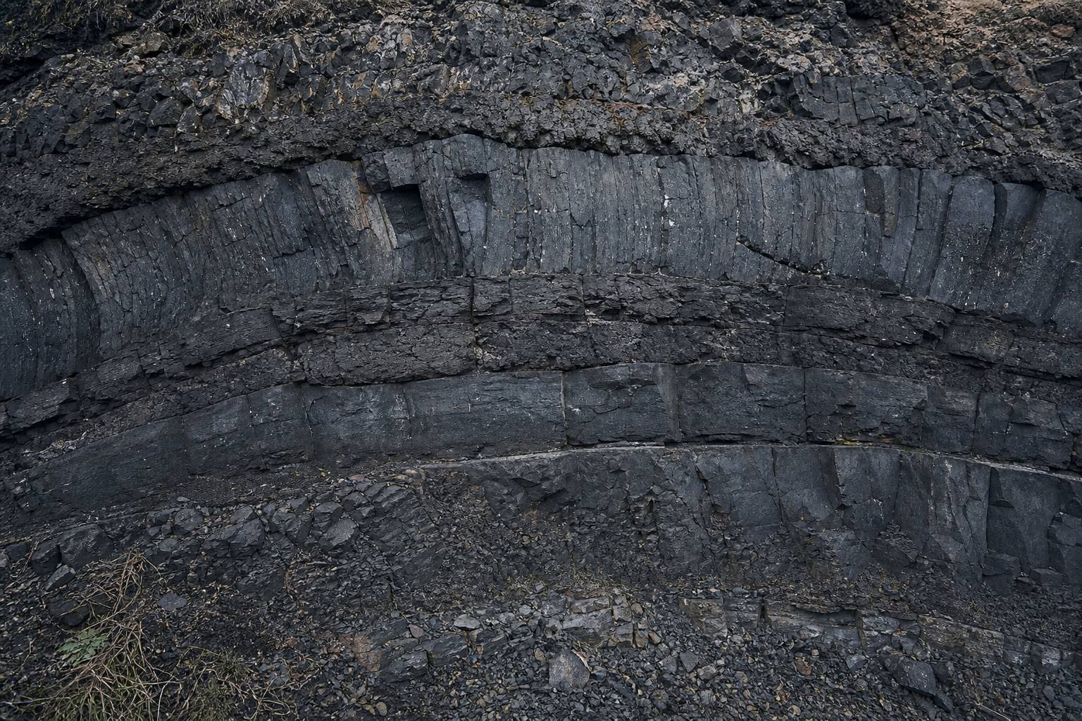 Dunkle Basaltstrukturen und geschichtetes Gestein in der Eifel