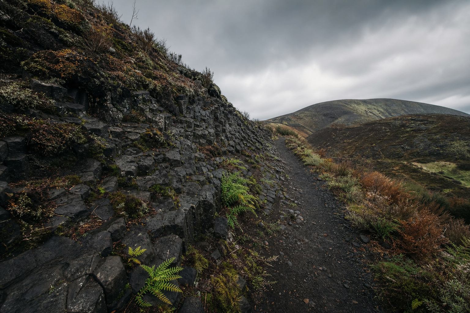 Basaltpfad am Kraterrand mit Blick auf Hügelland
